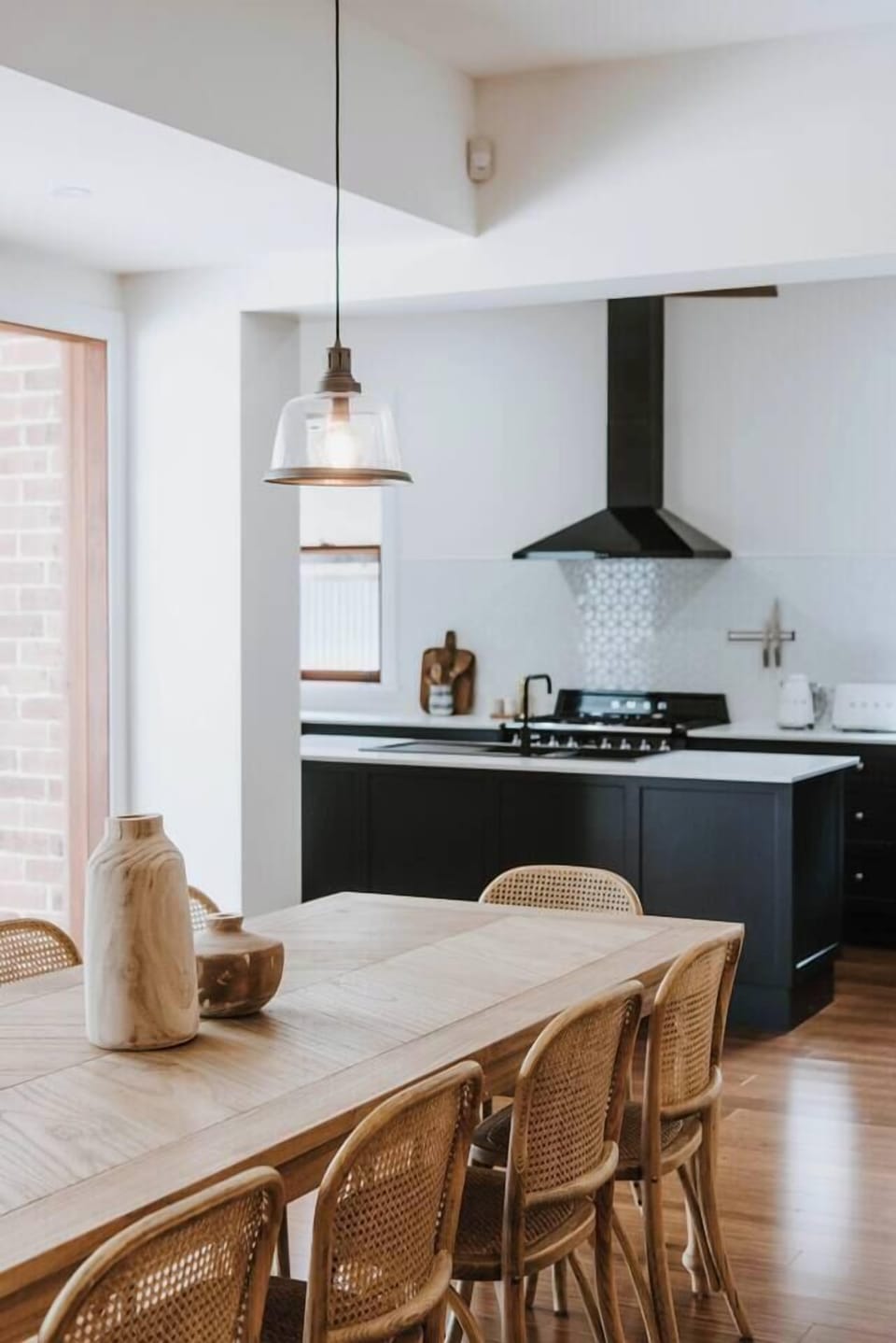 The dining area seamlessly flows into the striking monochrome kitchen.