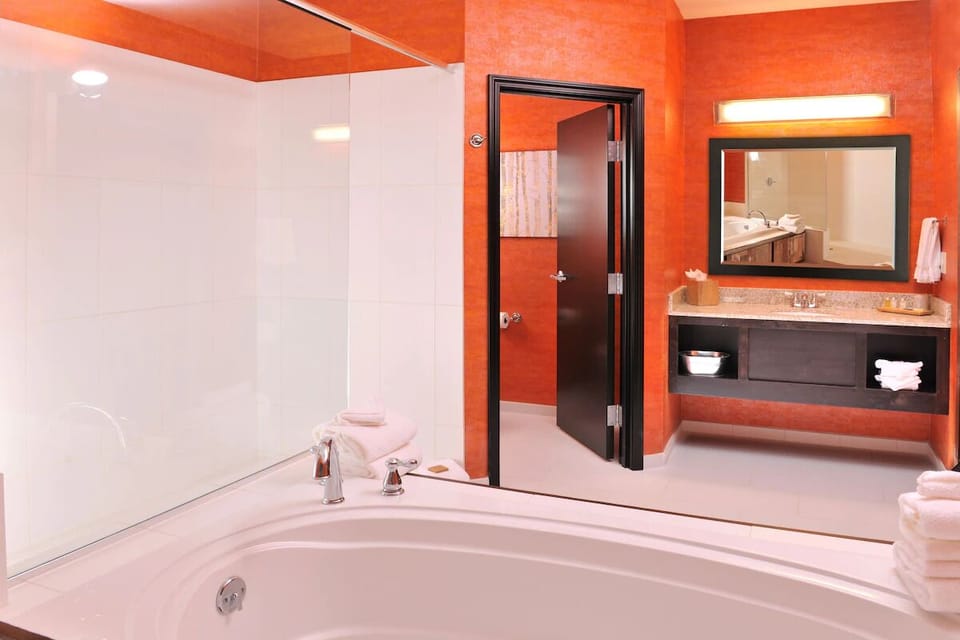 Refresh in a sleek bath with bright lighting and plenty of space.