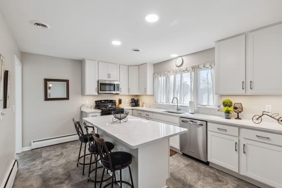 Natural lighting fills the newly renovated kitchen. Island seats three.
