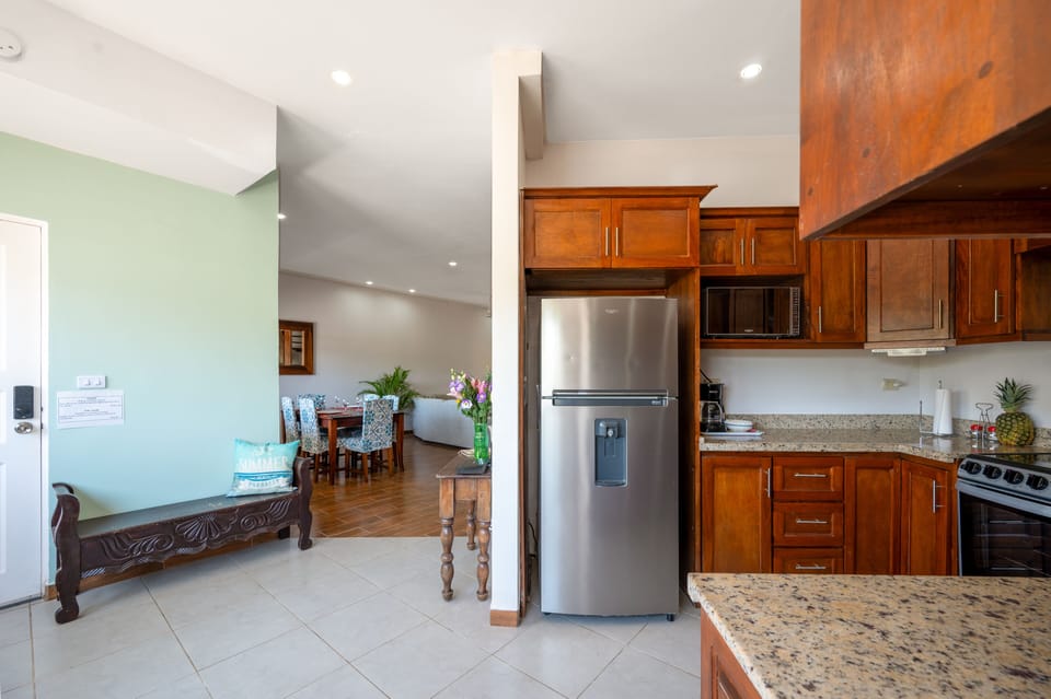 Open kitchen in this Tamarindo condo rental featuring a functional layout with modern appliances and a seamless flow into the dining area. Bright and inviting space ideal for cooking and gathering, located in the heart of Tamarindo near the beach.