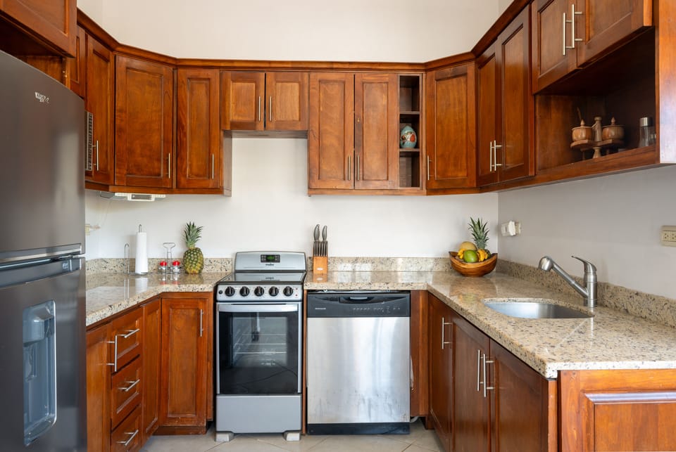 Fully equipped Tamarindo condo kitchen with modern appliances including microwave, toaster, blender, and coffee maker. Ideal for preparing family meals during your stay in Costa Rica vacation rentals with spacious open‑concept design.