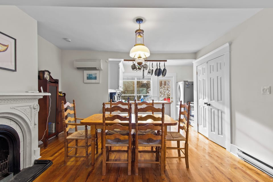 Gather around the classic wooden dining table beneath an elegant chandelier for memorable group meals.