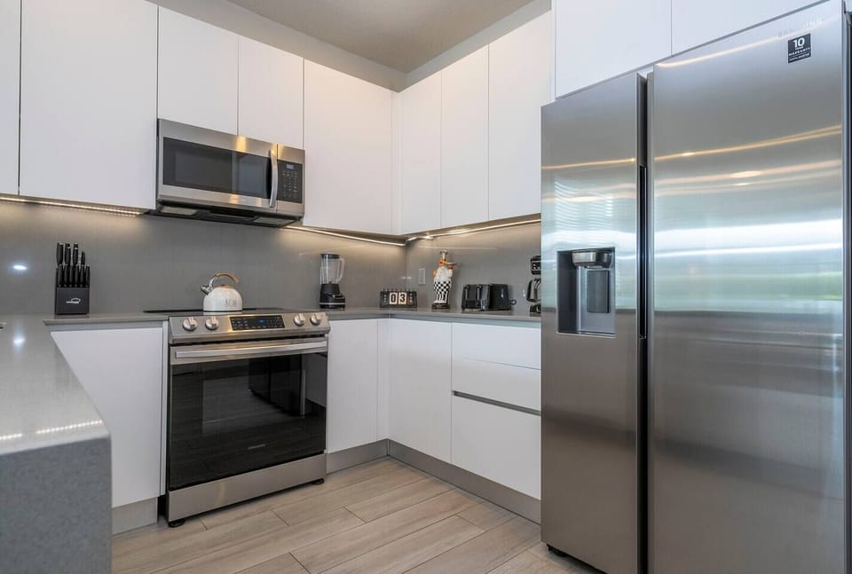 The fully equipped kitchen features modern appliances, sleek cabinetry, and all essential cookware and utensils, making it perfect for preparing meals with ease.