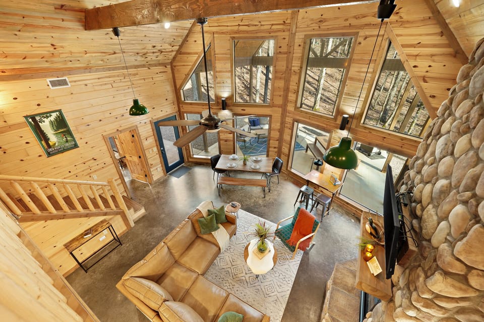 Take in the living room’s soaring ceilings and the floor-to-ceiling windows that provide natural light and views of nature.