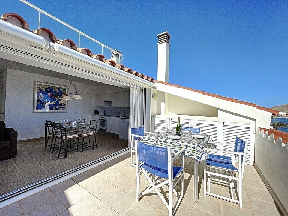 A bright, spacious terrace with sea views, accessible from the living room, dining room and kitchen through the open
