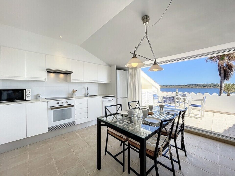 Kitchen and dining room equipped with dishwasher, large fridge and freezer, hob, and oven.