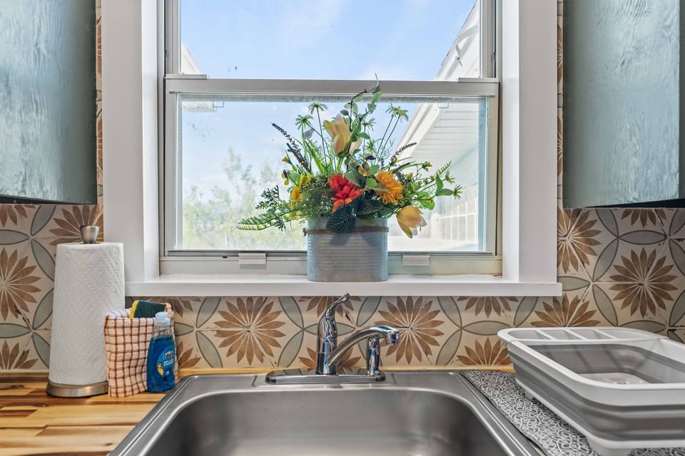 Charming kitchen with patterned backsplash, open shelving and bright natural light.