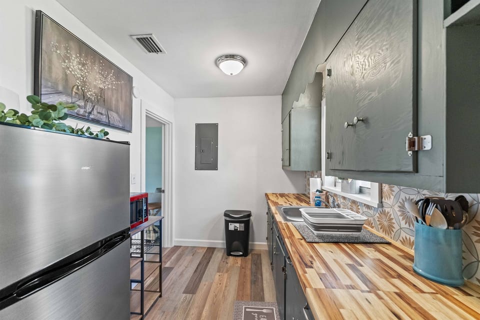 Galley kitchen equipped with full-size appliances, ample storage and stylish tile finishes.