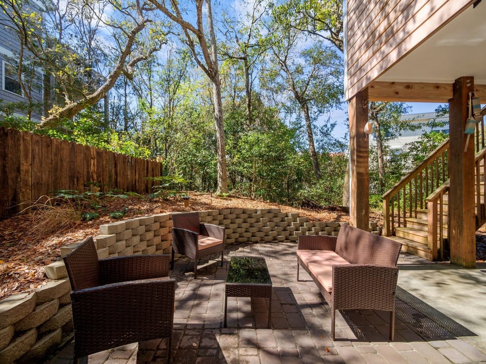 At the back of the house, there is a patio area with seating