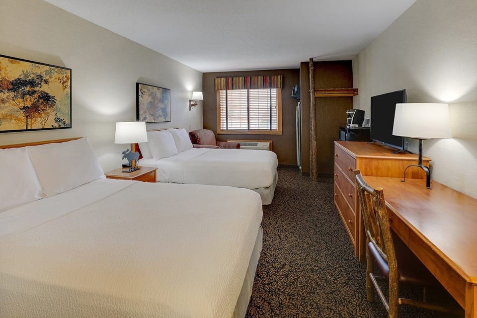 Settle in after adventures with two plush queens and workspace.