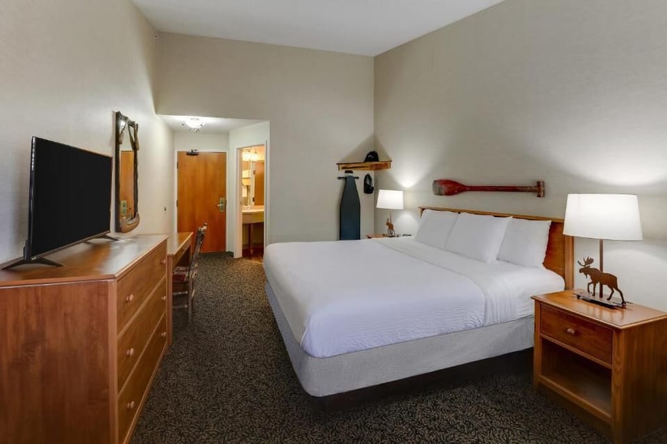 Unwind in a crisp king bed with warm lodge touches.