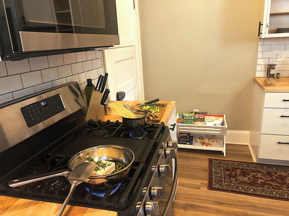 The kitchen is equipped with a gas range, stainless steel cookware, and utensils
