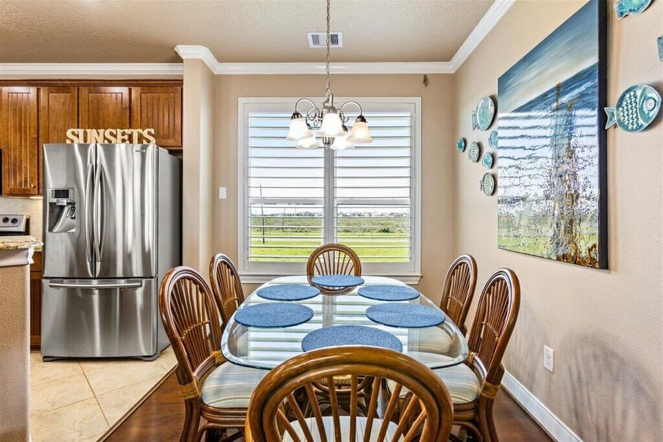 Bright dining area with natural light, seating for six, and coastal-themed decor
