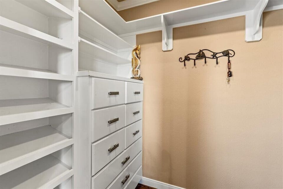 Spacious master closet with built-in shelving and ample storage space.
