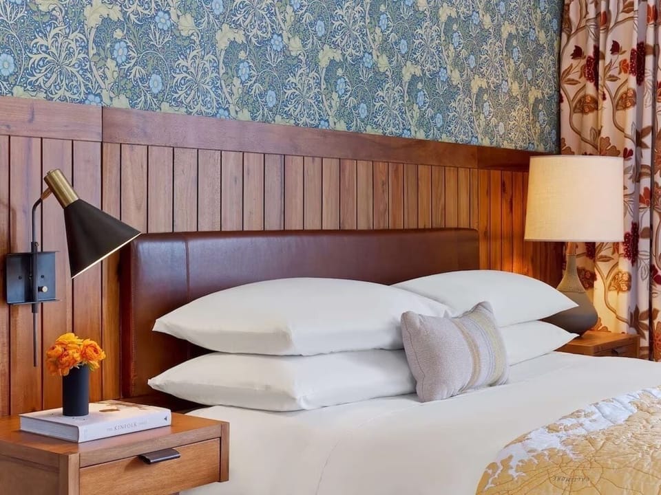 Sink into cloud-soft pillows under warm bedside lighting.