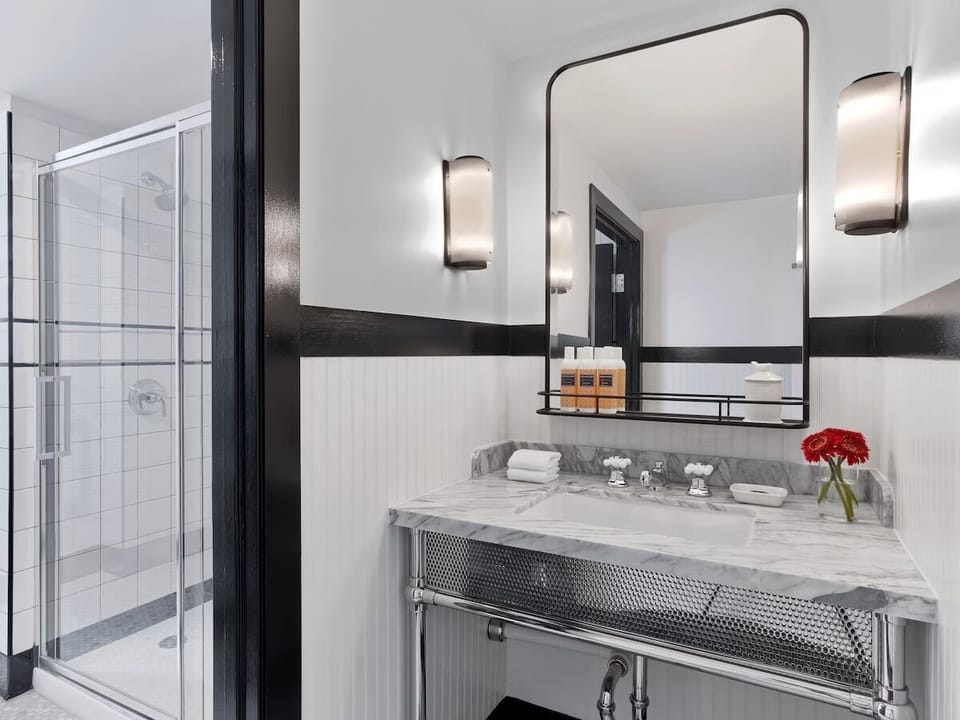 Refresh in a bright bath with marble vanity and walk-in shower.
