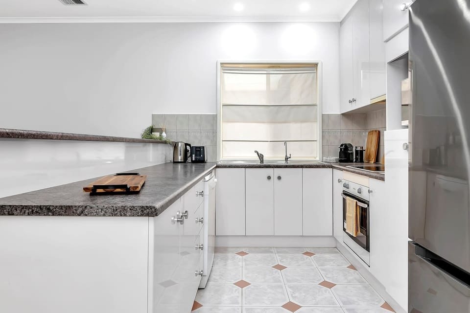 A modern kitchen features everything you’ll need to cook up a feast, with additional seating available at the breakfast bar. 
