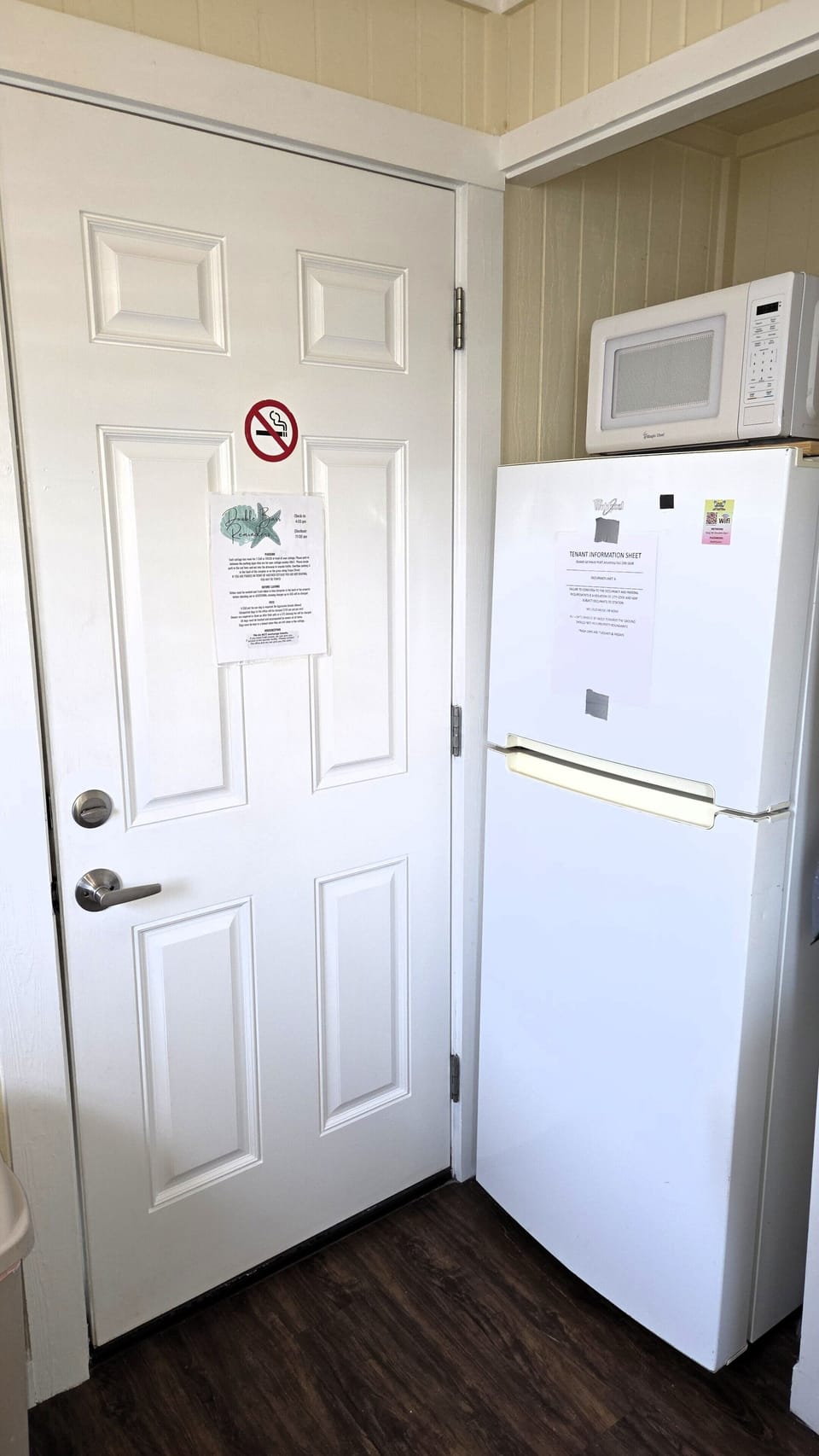 There is a refrigerator/freezer and a door than leads to a picnic area