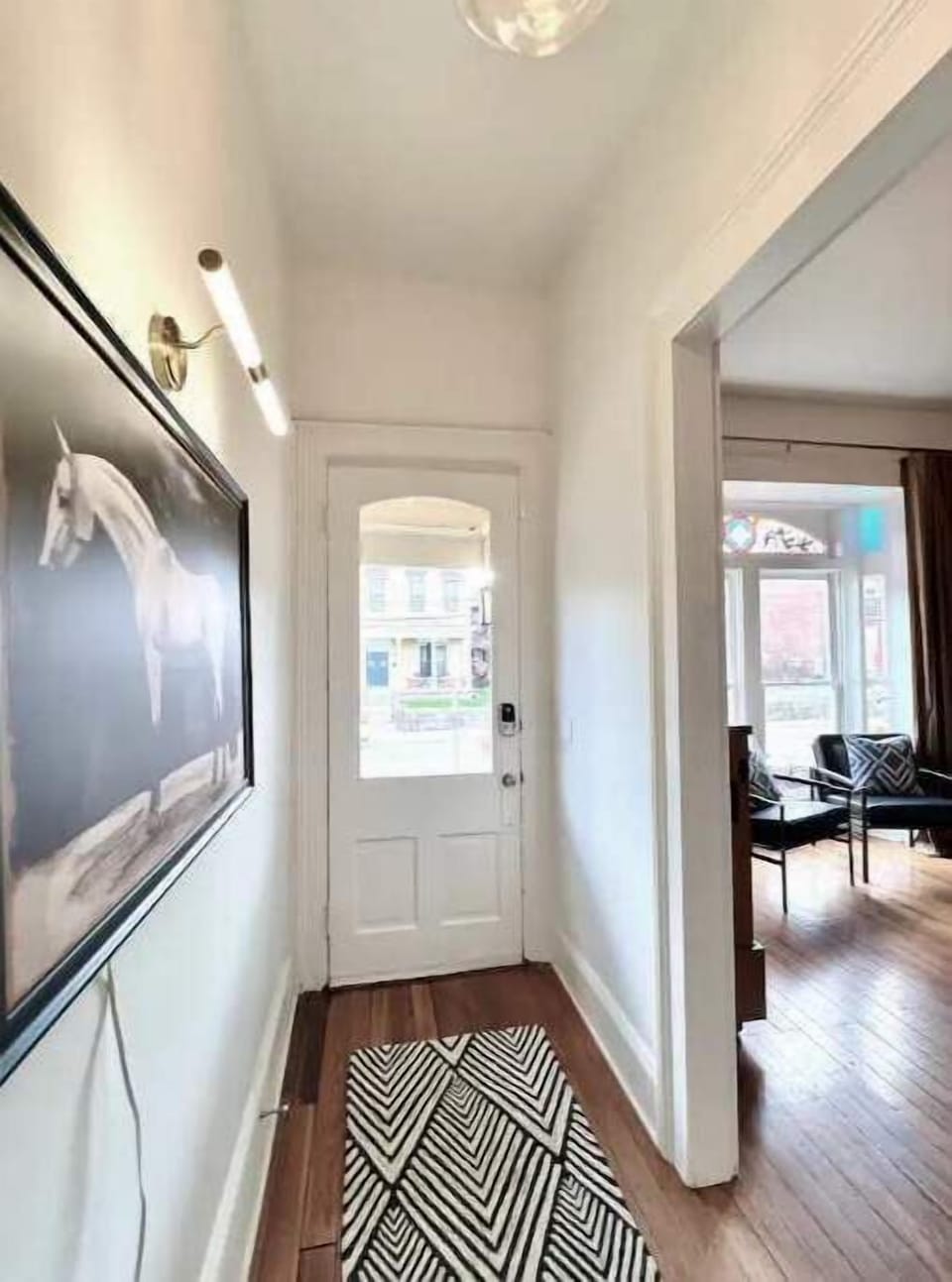  Bright entryway with modern art, smart lock, and hardwood floors