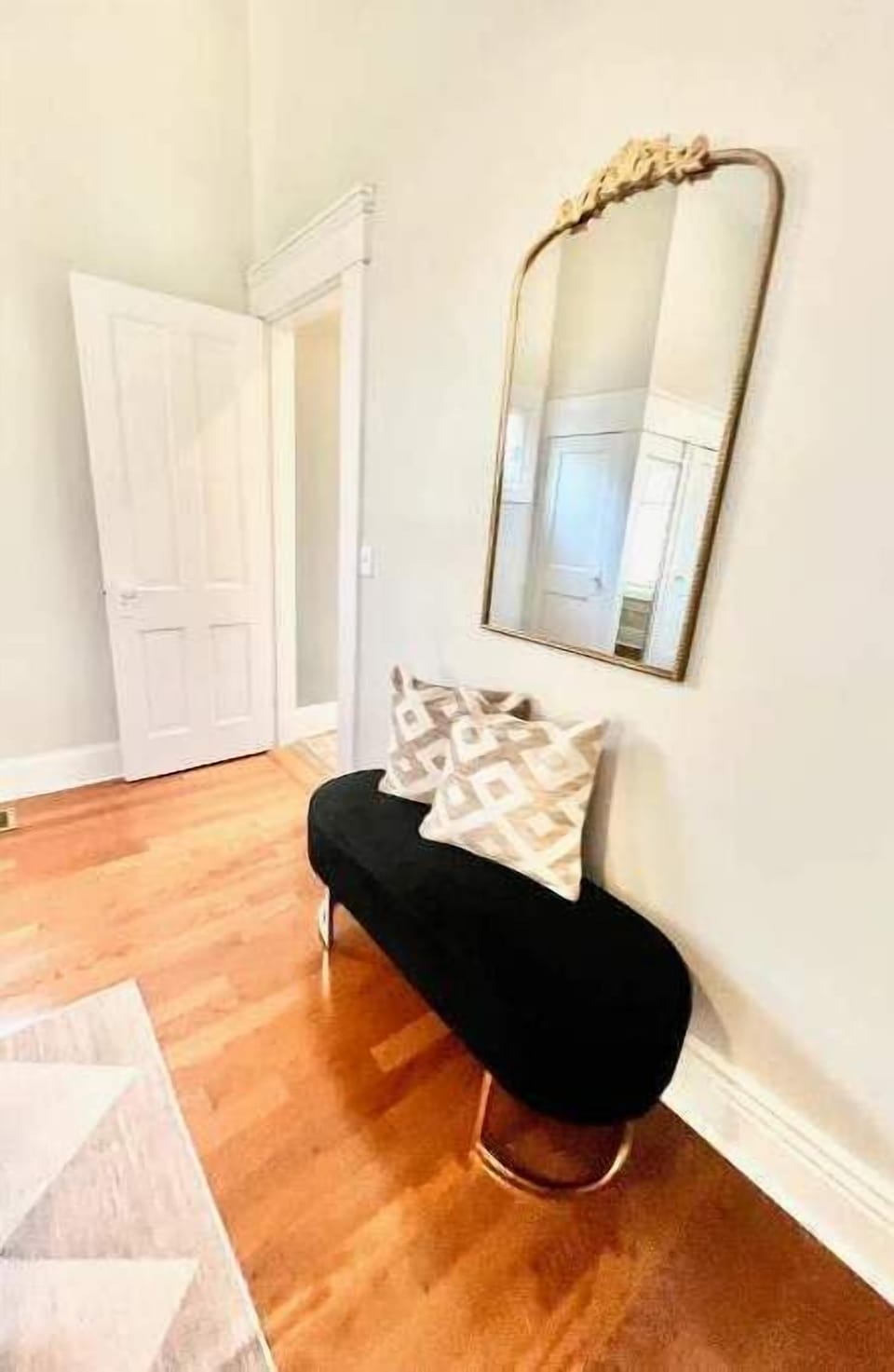  Chic bedroom bench with gold mirror and cozy accent pillows