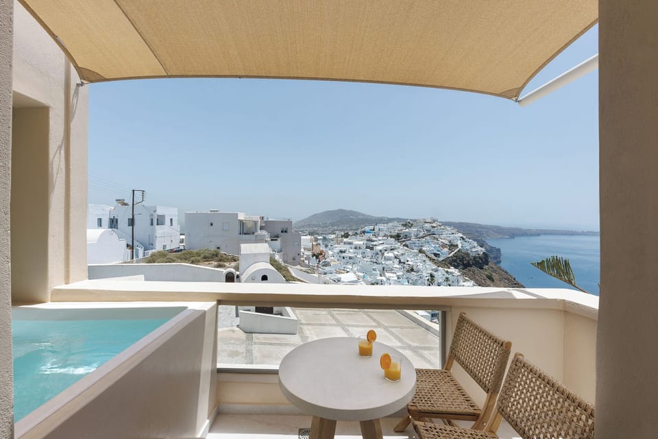 Private balcony with hot tub and view to Fira city and the sea
