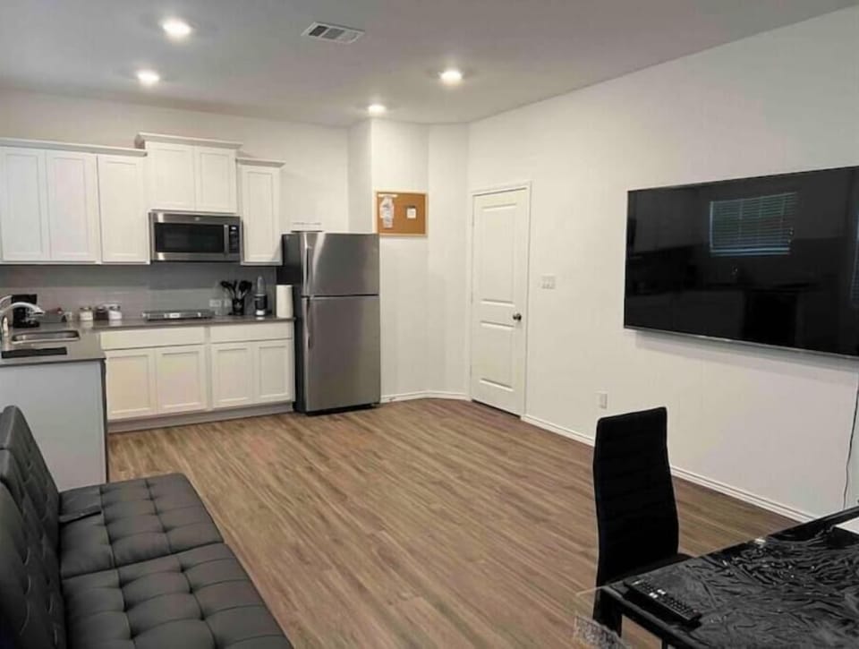 Spacious dining area, comfortable living room with a plush sofa and 75-inch TV.