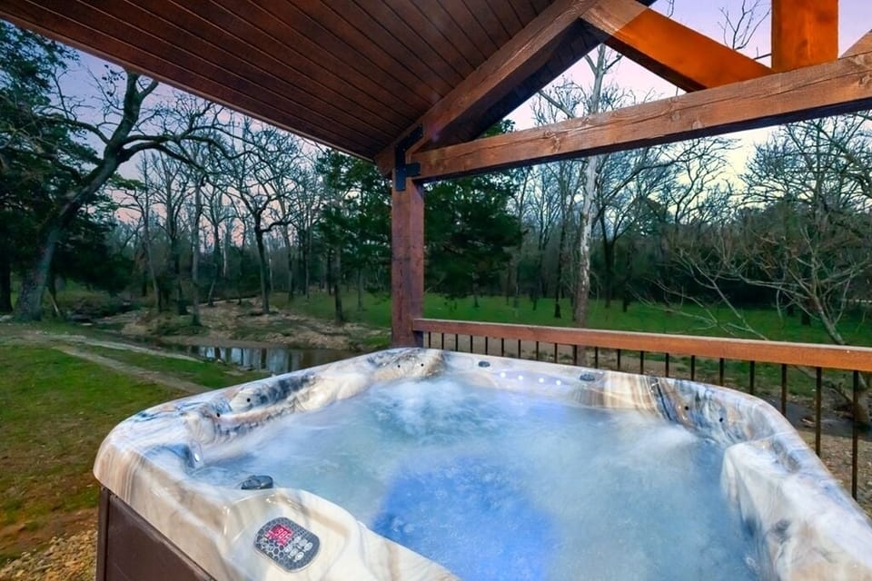 Covered hot tub overlooking creek