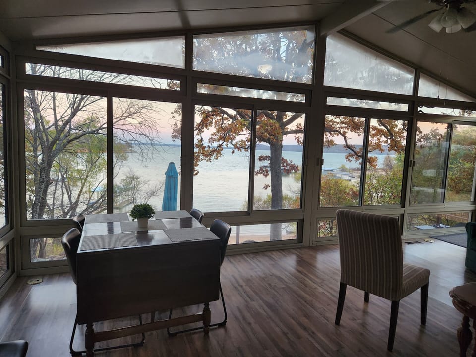 Additional dining table for 6 oversees the lake from the sunroom