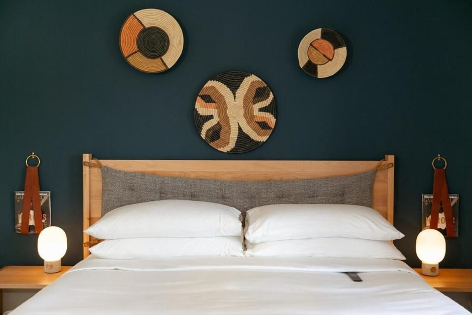 Unwind into crisp linens beneath bold, art-filled walls.