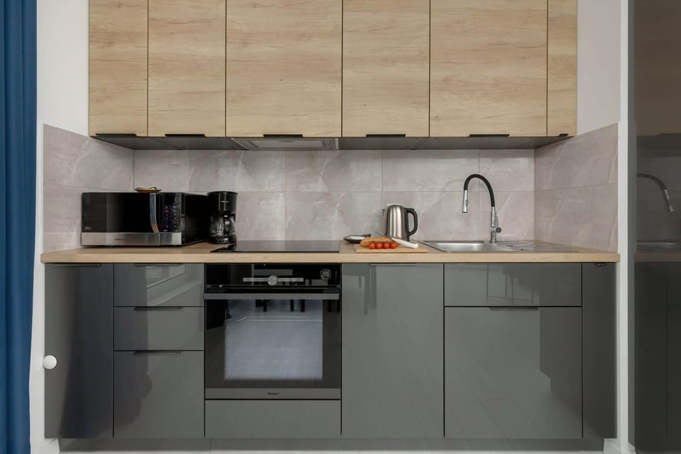 A modern kitchen featuring wooden cabinets, black appliances, and a sleek design.