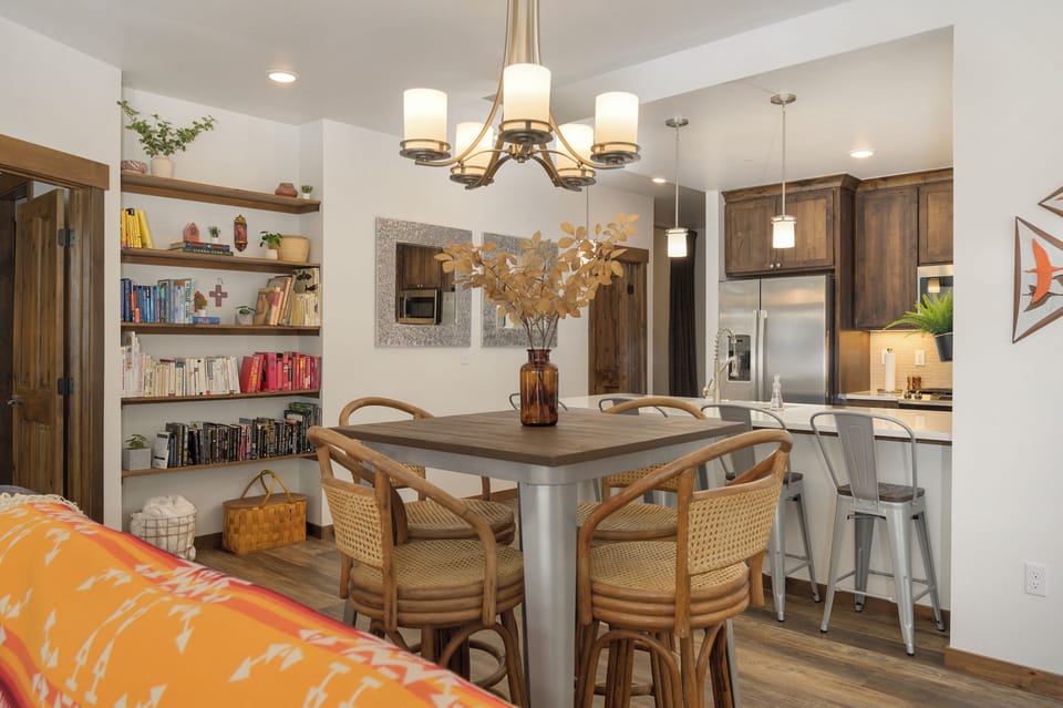 You'll love gathering around this stylish dining table with warm wood accents and thoughtful shelving filled with books and games.