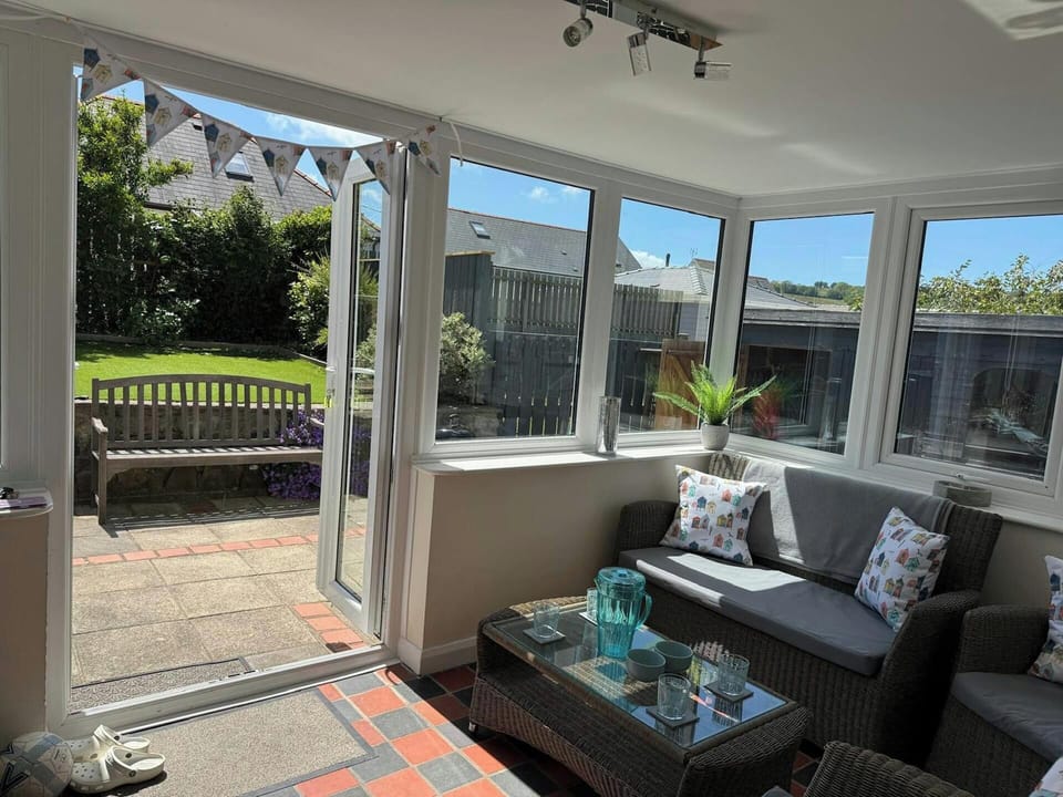 Conservatory with table and chairs and double doors leading to the garden