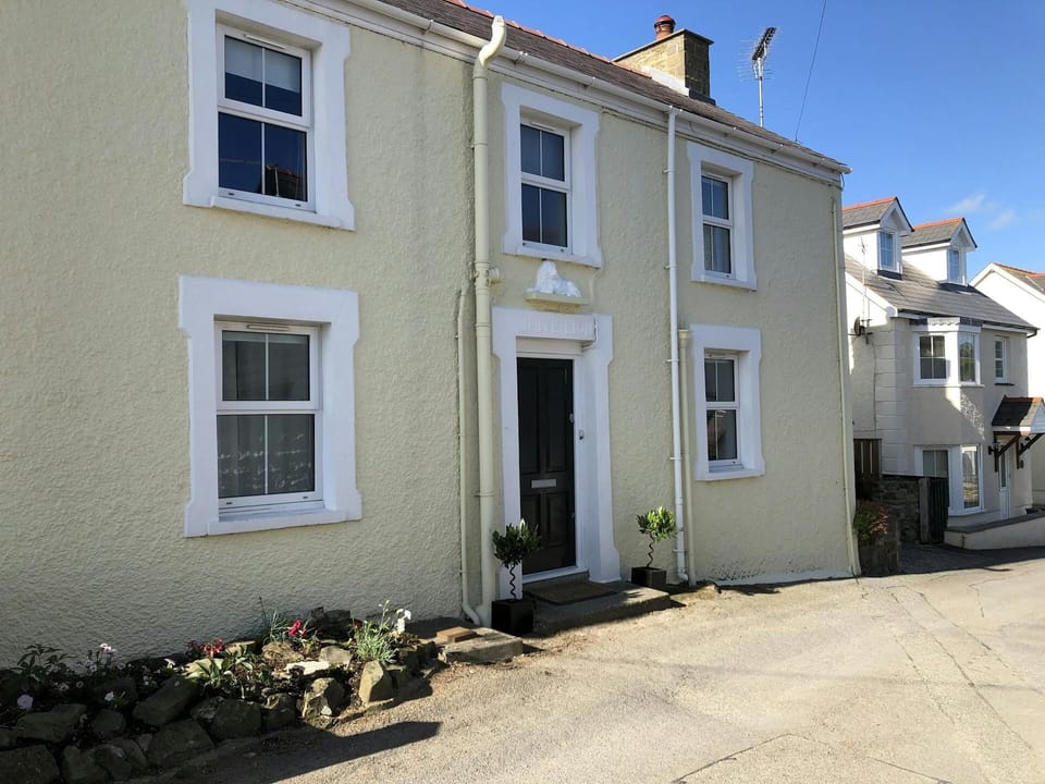 Front of White Lion, front door, road and small flower bed