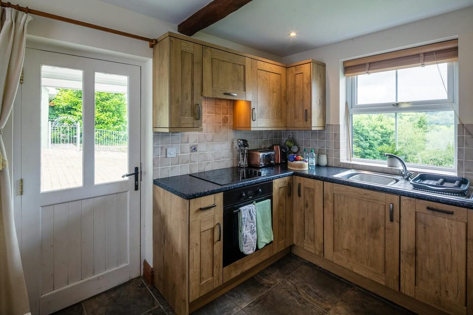 Fitted kitchen area: built-in oven, hob with extractor fan, toaster and kettle