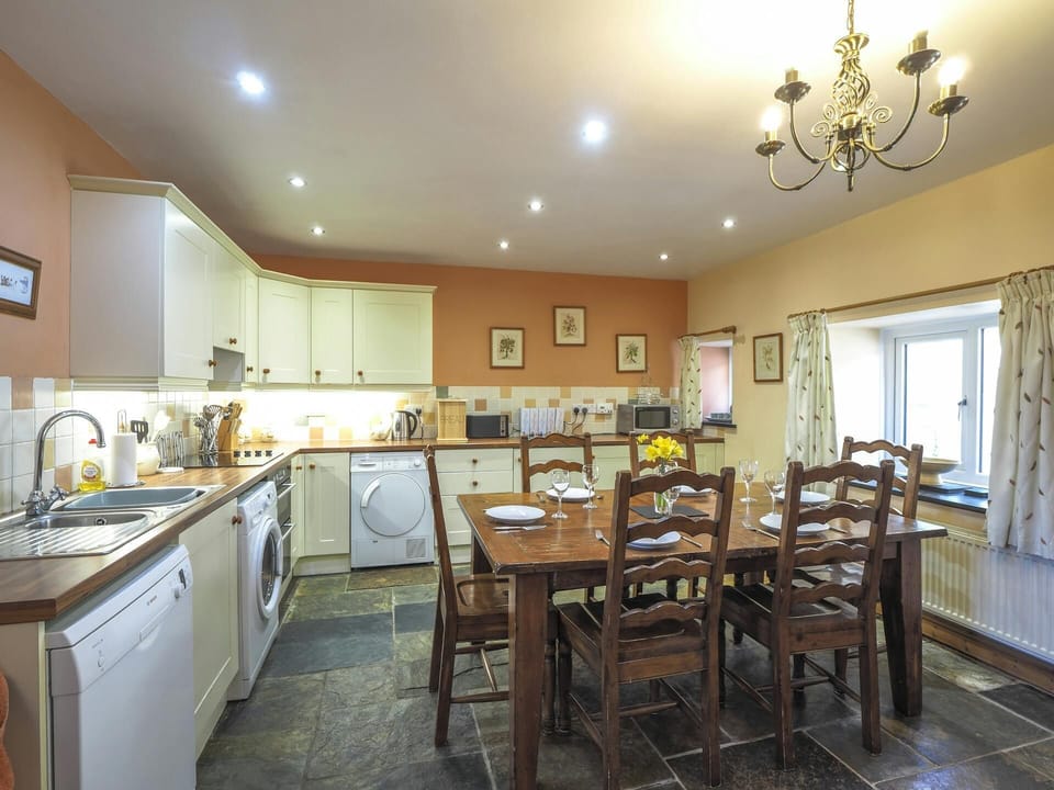 Fitted kitchen/diner with washing machine, dishwasher, microwave, kettle, toaster and dining table with six chairs