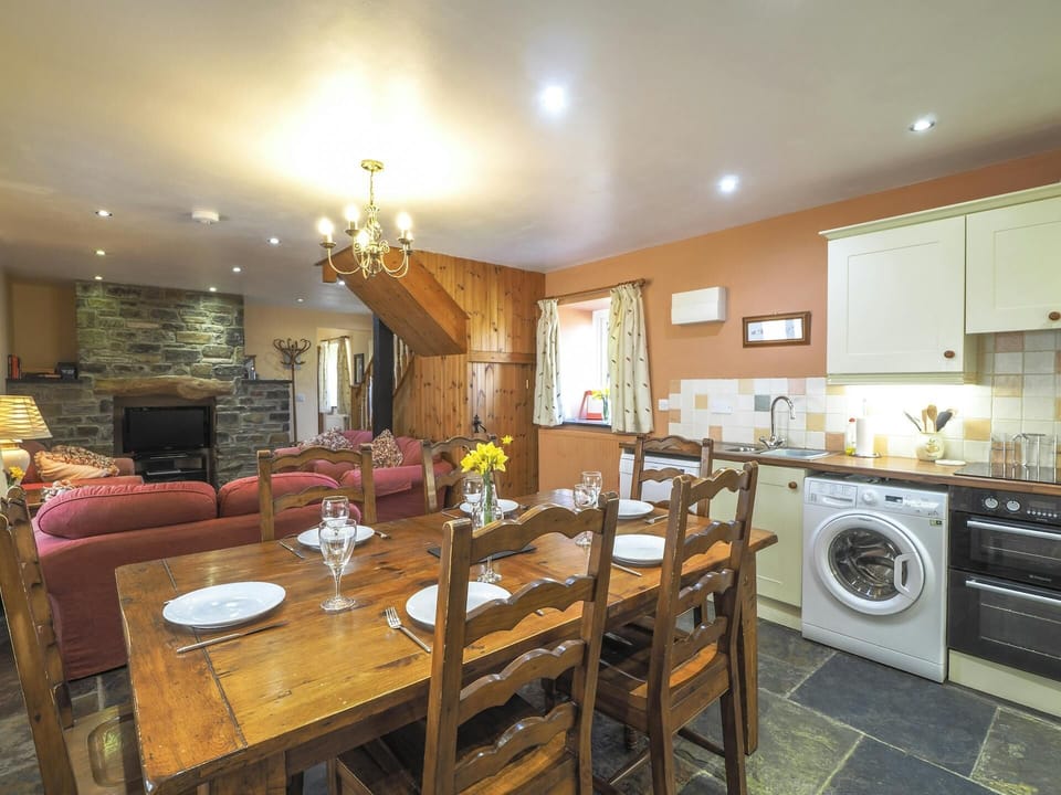 Kitchen/dining area with washing machine, electric oven and hob, dining table with six chairs