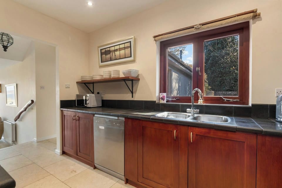 Kitchen with tiled floors and steps leading to the living accommodation