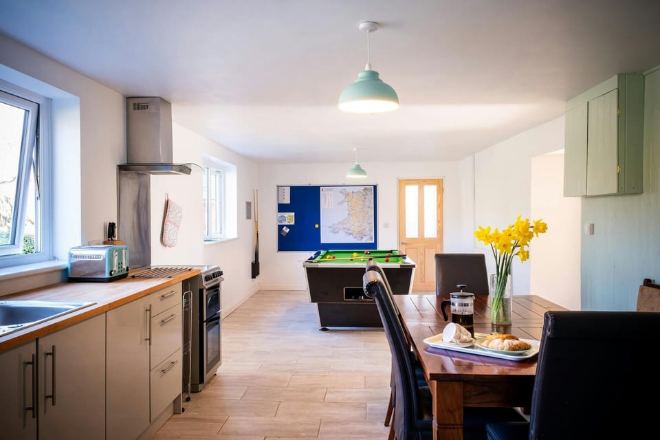Open plan kitchen/dining/games area: dining table with chairs and pool table