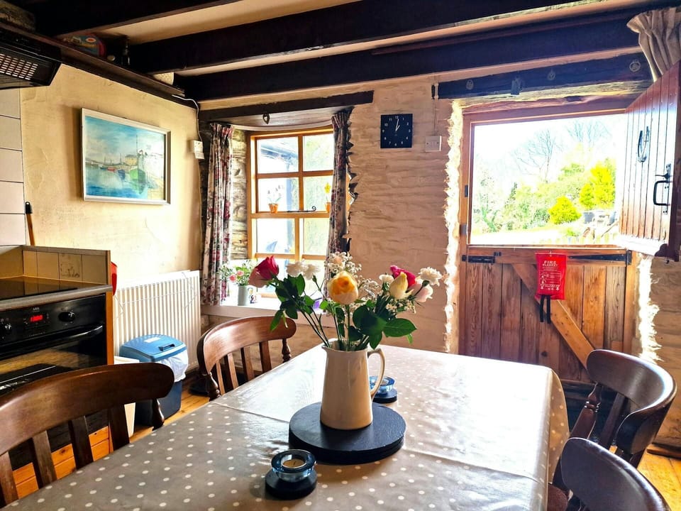 Dining table to seat four, with fresh flowers in a vase in the centre of table