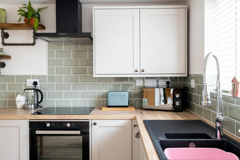 Oven, sink, wall cabinets, floor cabinets, toaster, microwave