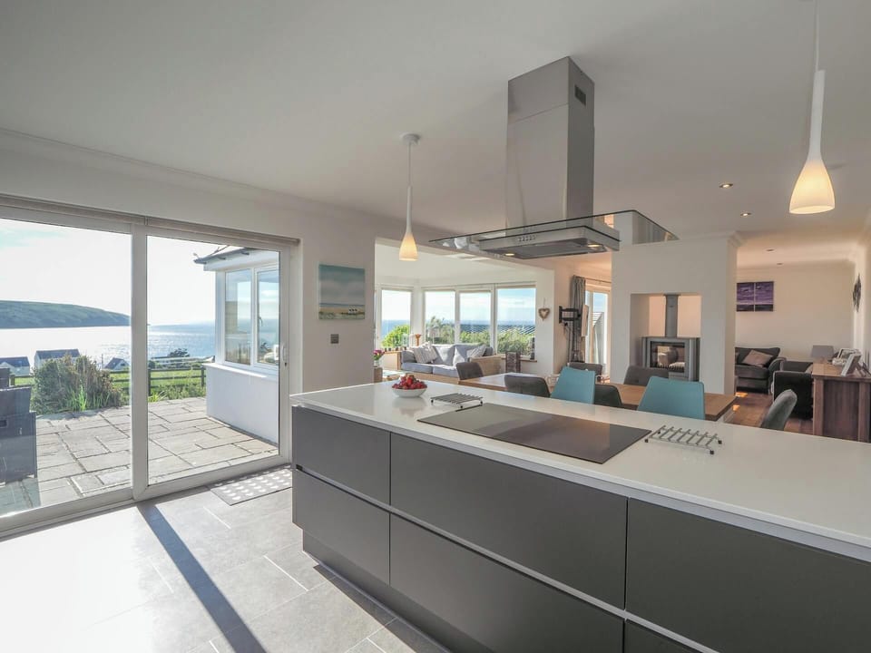Kitchen and living and dining area with double doors leading to patio, sea view