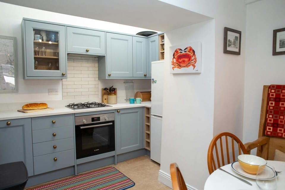 Kitchen with electric oven, gas hob and fridge freezer