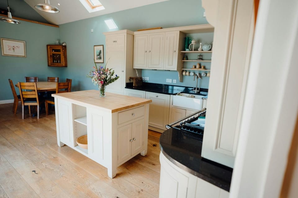 Kitchen with island unit with a vase of flower so top