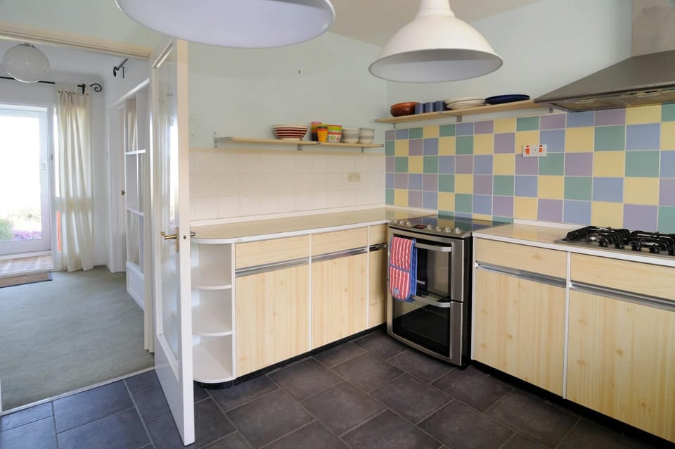 Kitchen with cooker, gas hob, kitchen units and open shelf