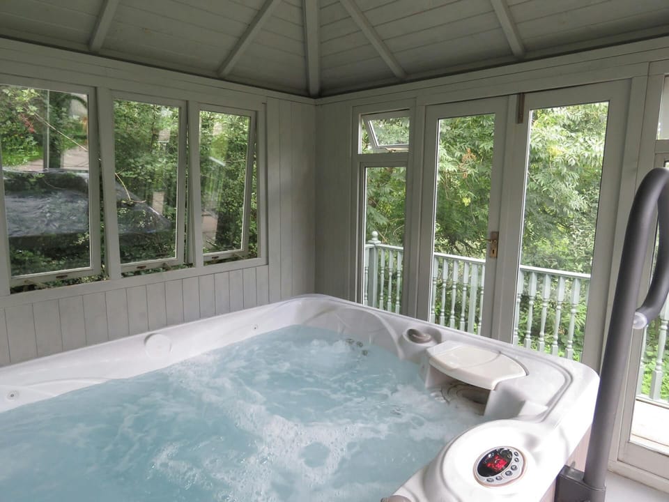Hot tub in covered conservatory building with garden views