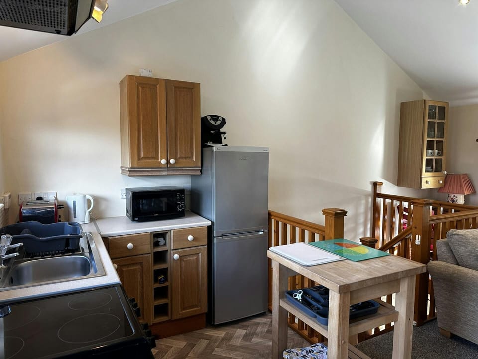 Microwave, fridge/freezer, kettle, toaster, sink and table