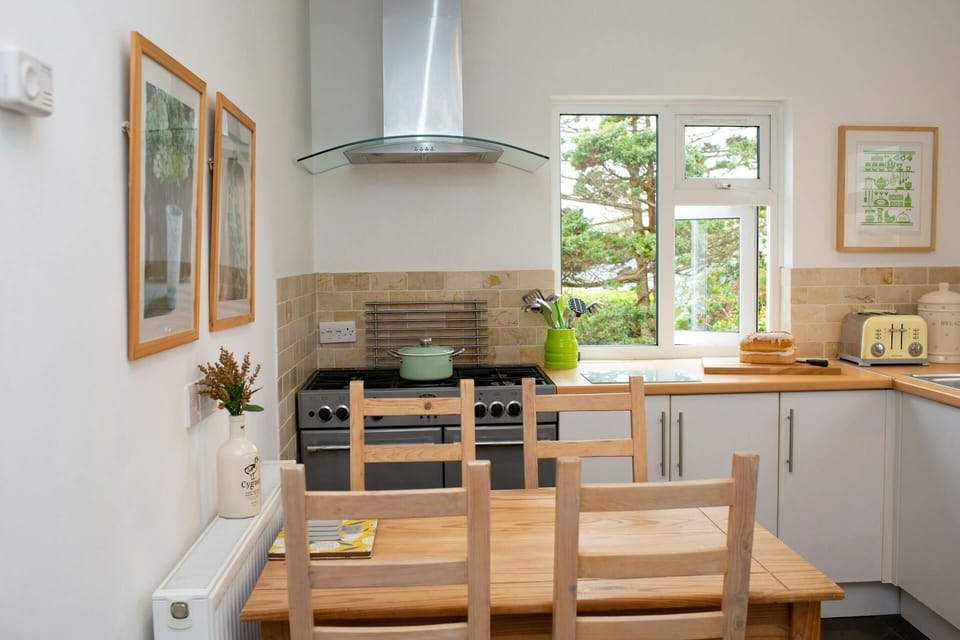 Kitchen with range cooker, toaster, dining table and four chairs