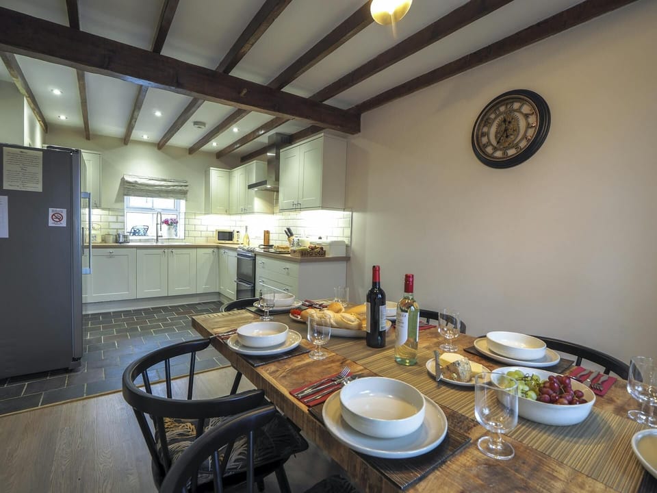 Dining are leading to kitchen. Wooden floors and beamed ceiling
