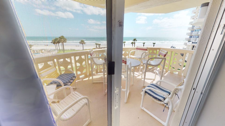 Siding door from primary suite to balcony. High top table and chairs.