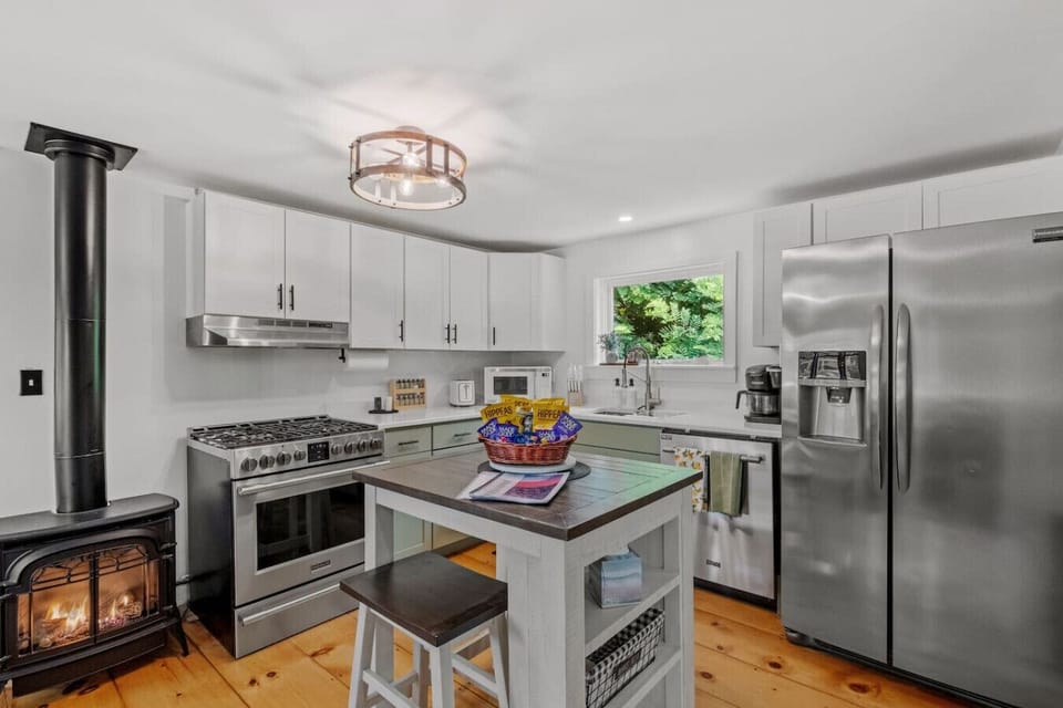 Cook, gather, and unwind in this bright kitchen featuring island seating and a charming wood stove